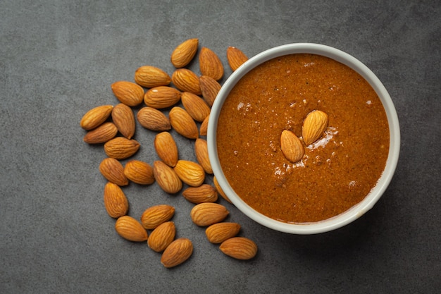 Photo gratuite beurre d'amandes biologiques crus sur fond sombre