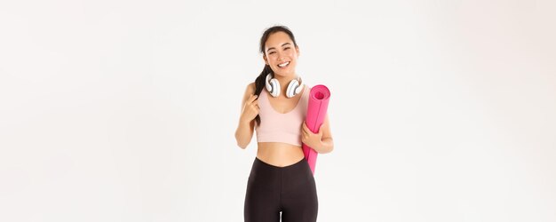 Bien-être sportif et concept de mode de vie actif smiling happy asian fitness girl in headphones et spor