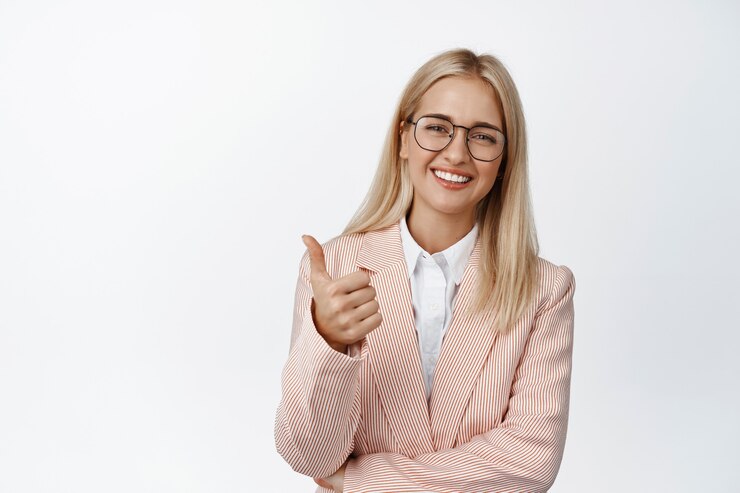 Photo gratuit bien fait. jeune femme d'entreprise, entrepreneur en costume et lunettes montre des pouces et des sourires heureux sur blanc