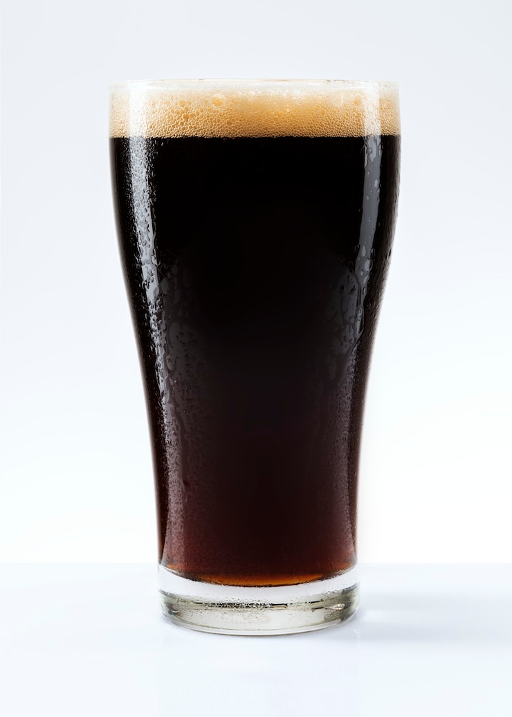Photo gratuit bière brune avec de la mousse dans une pinte