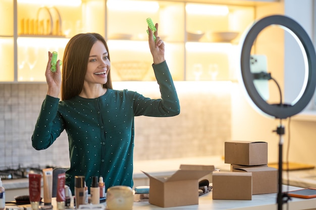 Les bigoudis. Souriante jeune femme montrant des conseils sur la coiffure avec des bigoudis