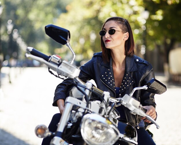 Biker girl dans une veste en cuir sur une moto