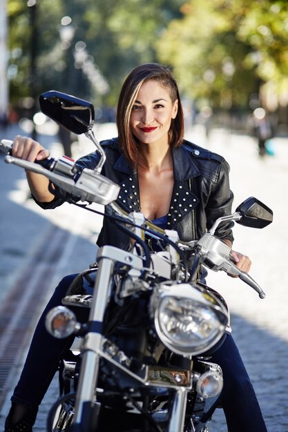 Biker girl dans une veste en cuir sur une moto