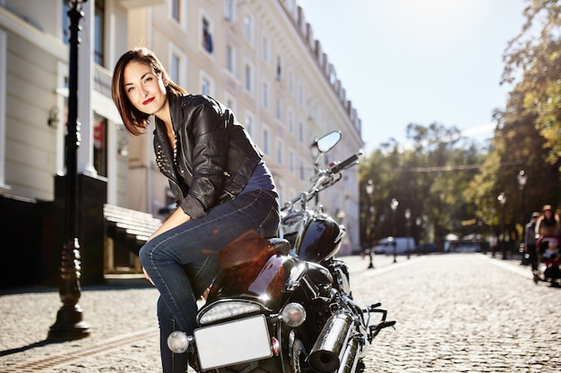 Biker girl dans une veste en cuir sur une moto