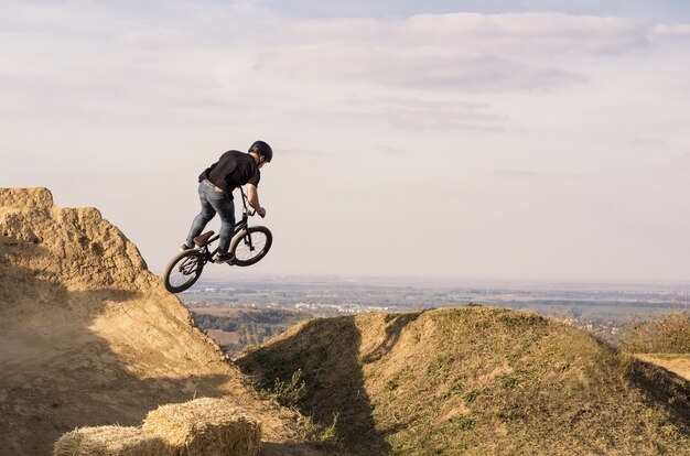 Biker sautant et volant au-dessus d'une colline