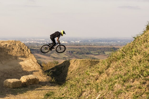 Biker sautant et volant au-dessus d'une colline