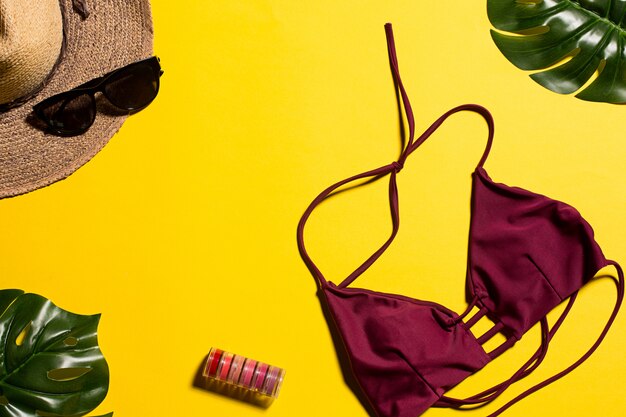 Bikini, feuilles et chapeau sur jaune