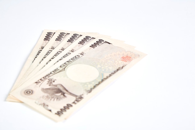 Billets de yen japonais et pièce de yen japonais sur fond blanc