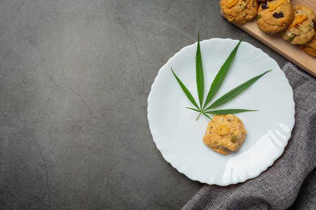 Biscuit au cannabis et feuille de cannabis mis sur plaque blanche
