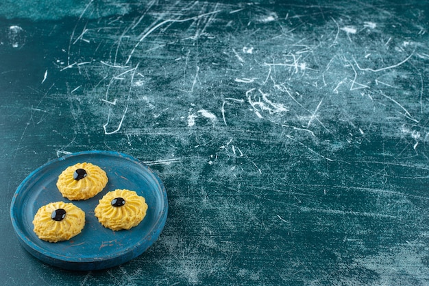 Biscuit au chocolat sur une plaque en bois, sur fond bleu. photo de haute qualité