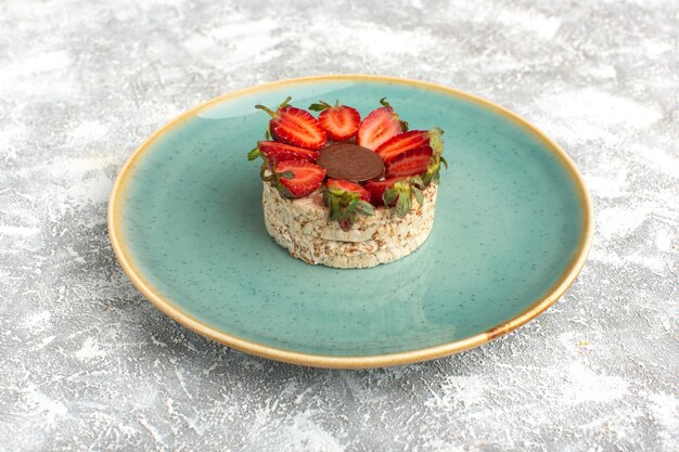 Biscuit aux fraises et chocolat rond à l'intérieur de la plaque bleue