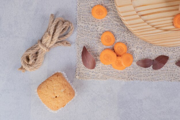 Biscuit doux, tranches de corde et de carottes sur fond de marbre. Photo de haute qualité