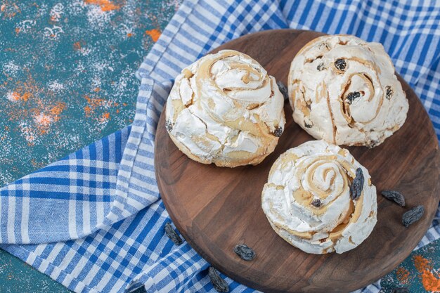 Biscuit de meringue frit avec des raisins secs noirs sur une planche de bois.