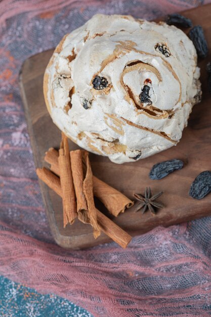 Biscuit de meringue frit avec des raisins secs noirs sur une planche de bois.