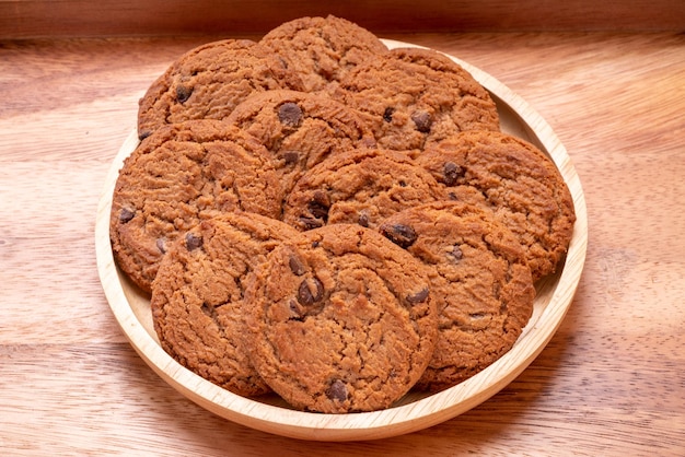 Biscuits au beurre dans une assiette en bois sur fond de bois biscuits aux pépites de chocolat prêts à servir