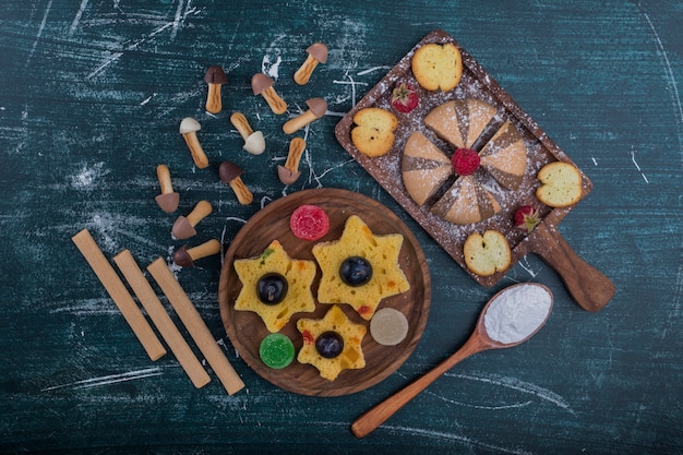 Biscuits au cacao et à la vanille sur une planche en bois avec des biscuits en forme d'étoile de côté