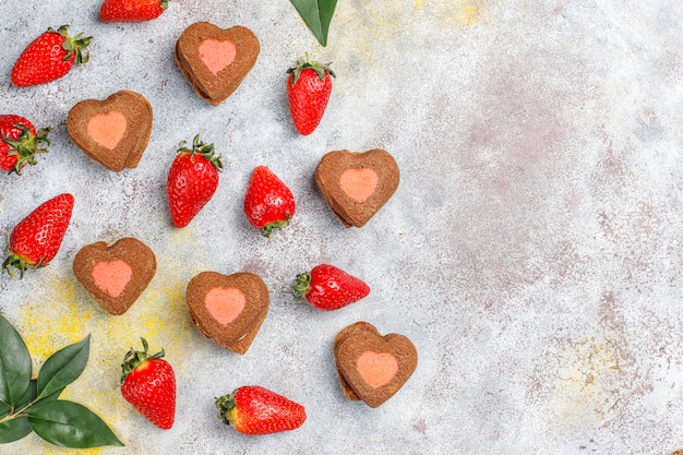 Biscuits au chocolat et aux fraises en forme de coeur avec des fraises fraîches