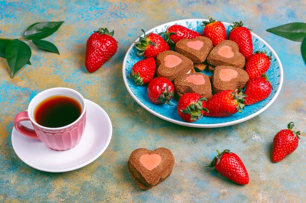 Biscuits au chocolat et aux fraises en forme de coeur avec des fraises fraîches