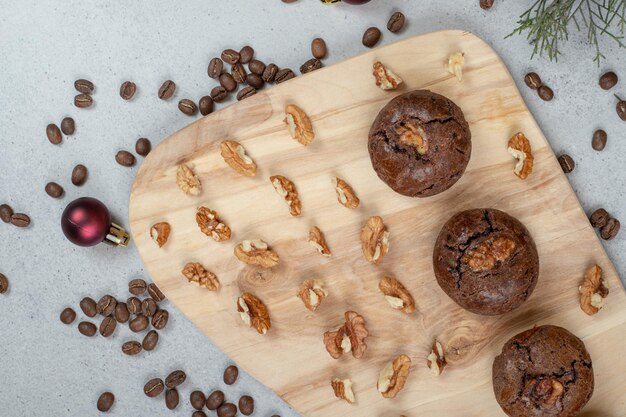 Biscuits au chocolat aux noix et grains de café avec boule de Noël sur planche de bois.