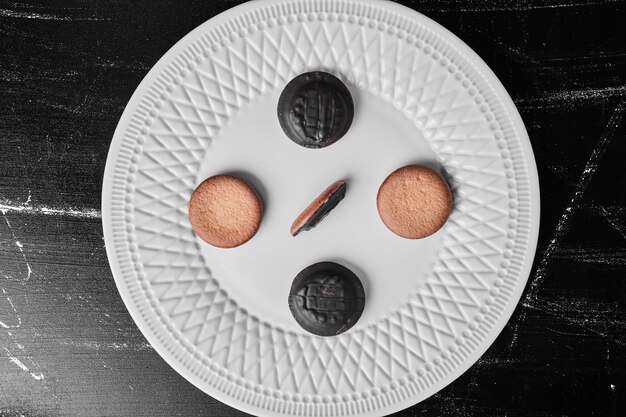 Biscuits au chocolat avec biscuits à la vanille dans une assiette blanche.