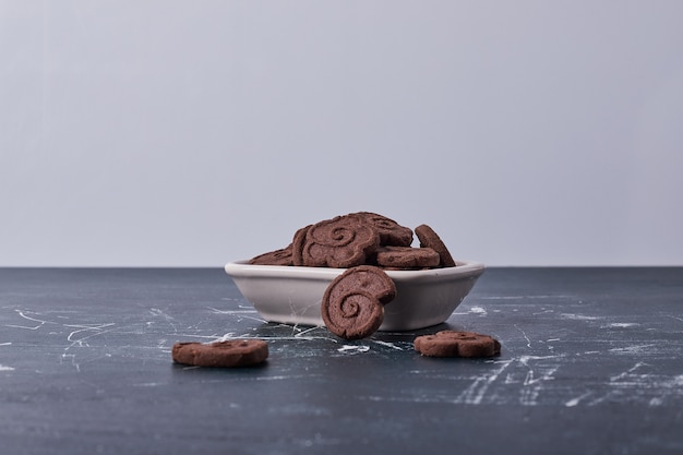 Biscuits au chocolat dans une assiette en céramique blanche.