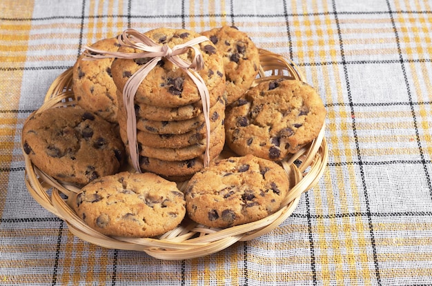 Biscuits au chocolat dans une assiette en osier sur une nappe jaune