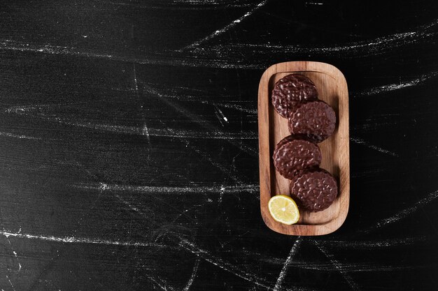 Biscuits au chocolat dans une planche de bois.