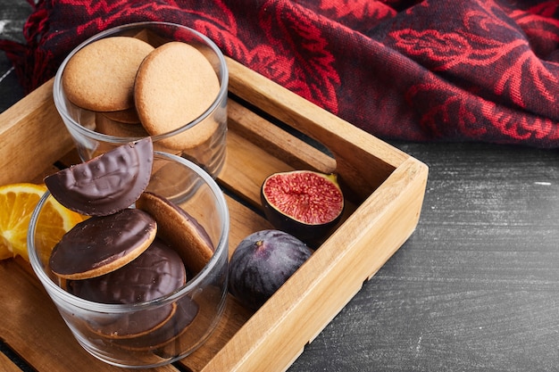 Biscuits au chocolat dans un plateau en bois.