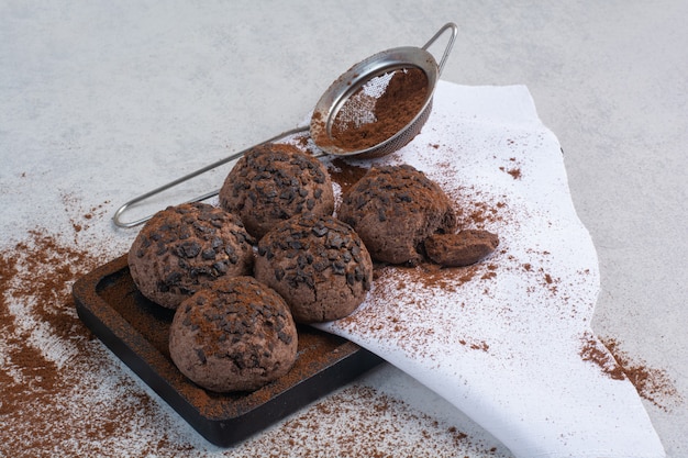 Biscuits au chocolat avec du cacao en poudre sur plaque en bois