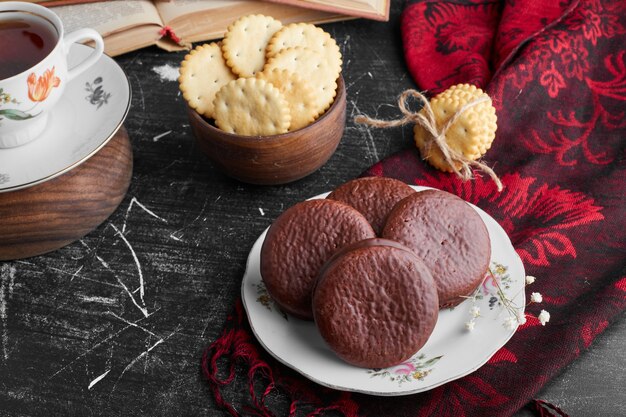 Biscuits au chocolat à la guimauve avec une tasse de thé et des craquelins.