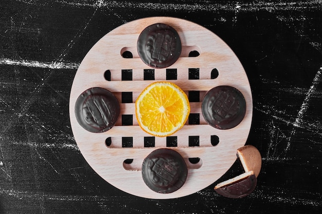 Biscuits au chocolat sur un plateau en bois avec du citron.