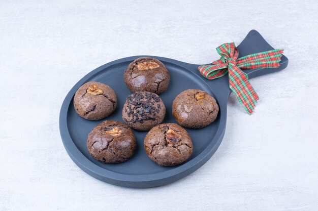 Biscuits au chocolat sur tableau noir avec ruban. photo de haute qualité