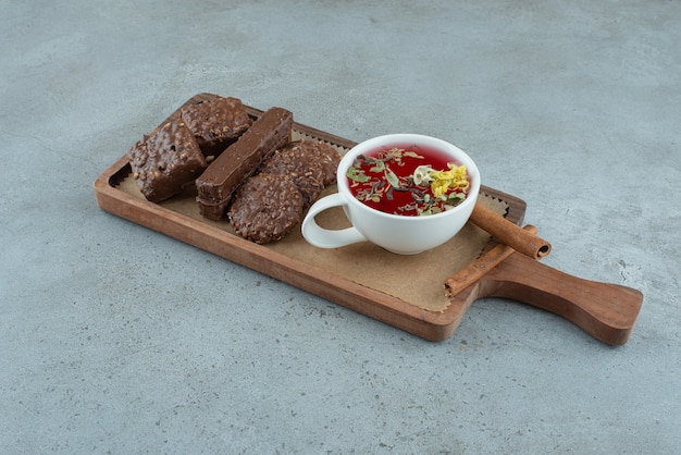 Biscuits au chocolat et tasse de thé sur planche de bois. photo de haute qualité