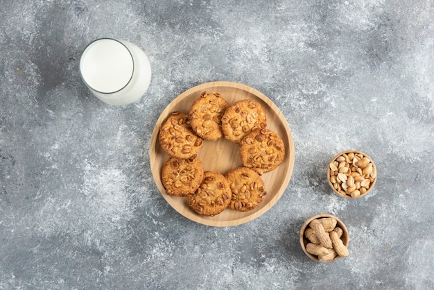 Biscuits aux cacahuètes biologiques et verre de lait sur table en marbre.