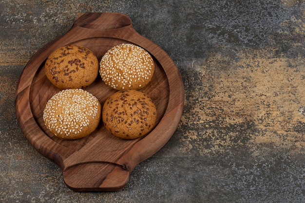 Photo gratuite biscuits aux graines de sésame et morceaux de chocolat sur planche de bois.