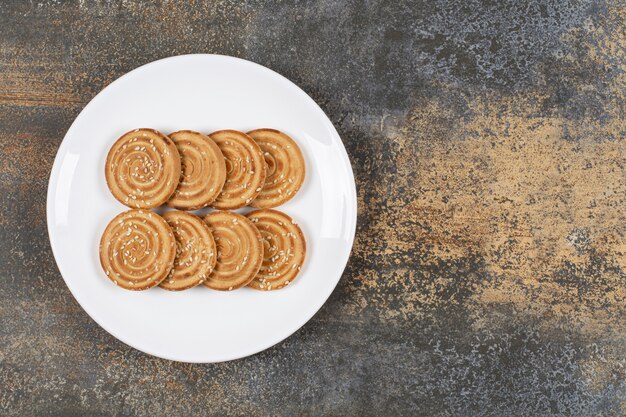 Biscuits aux graines de sésame sur plaque blanche.