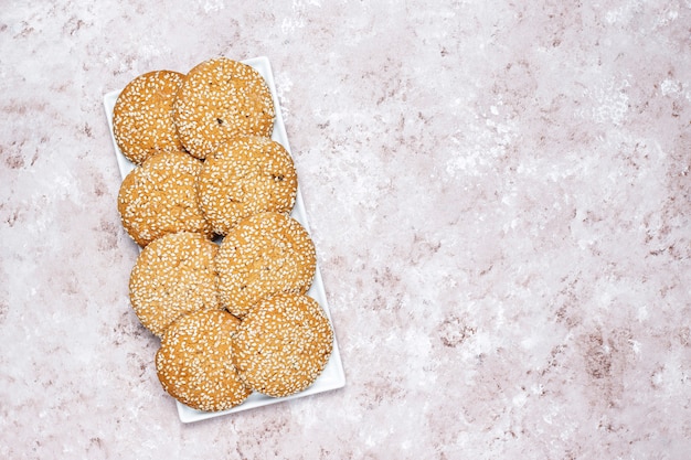 Biscuits aux graines de sésame de style américain sur fond de béton clair.