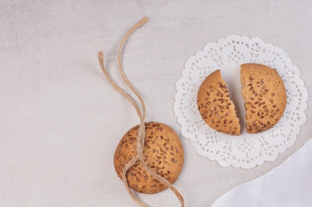 Biscuits aux graines de sésame sur une surface blanche.