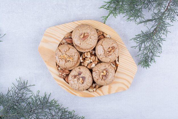 Biscuits aux noyaux de noix sur plaque en bois.