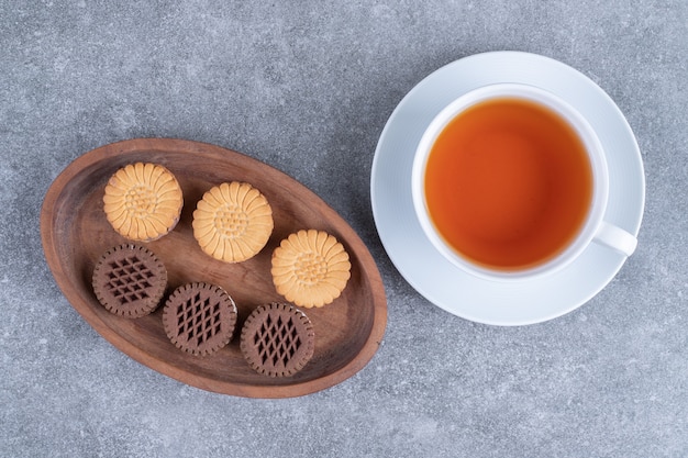 Biscuits d'avoine et de cacao avec une tasse de thé sur une surface en marbre