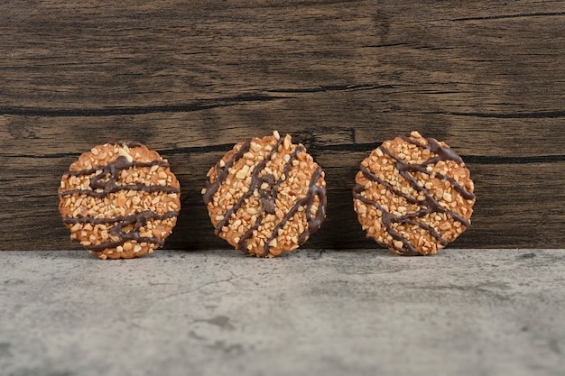 Biscuits à l'avoine fraîchement sortis du four saupoudrés de graines sur du marbre.