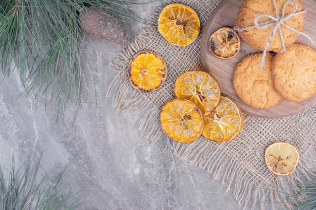 Biscuits à l'avoine sur un plateau en bois avec des tranches d'orange sèches autour