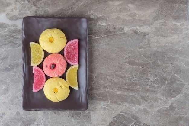 Photo gratuite biscuits et bonbons à la gelée regroupés sur un plateau sur une surface en marbre