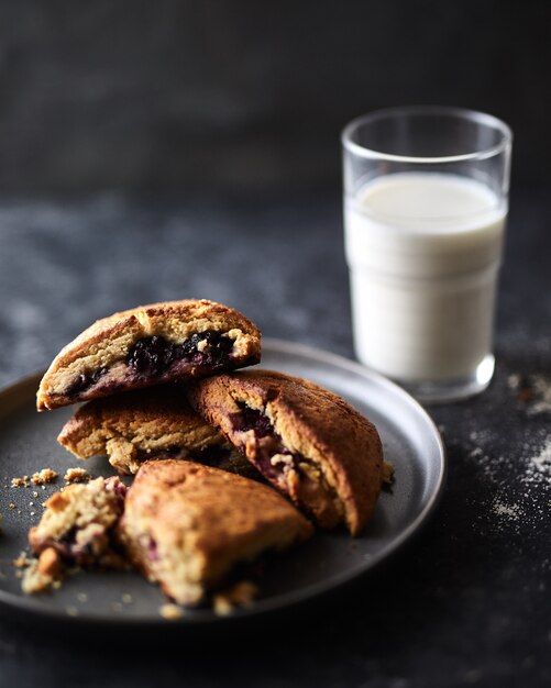 biscuits avec une confiture de baies et un verre de lait avec un arrière-plan flou