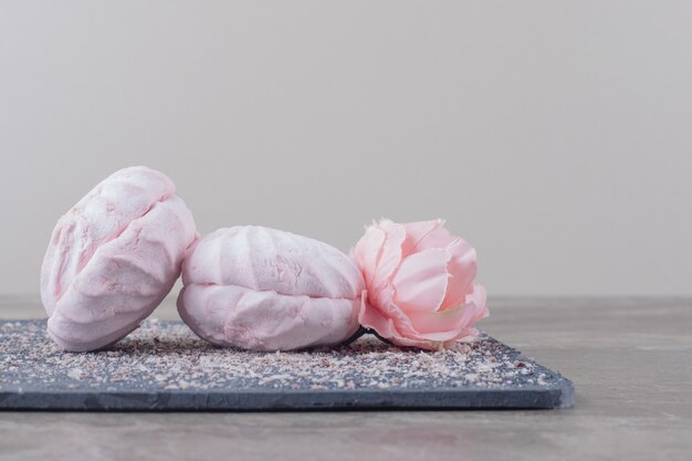 Biscuits et une corolle de fleurs sur une planche en marbre