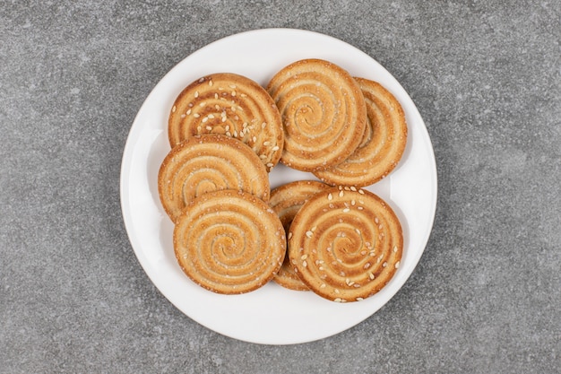 Biscuits croquants aux graines sur plaque blanche.