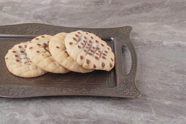 Biscuits croustillants sur un plateau orné sur marbre