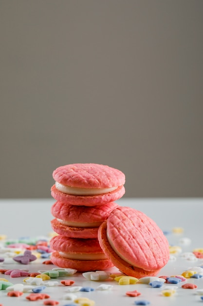 Biscuits de fête avec des pépites de sucre sur une table blanche et grise,