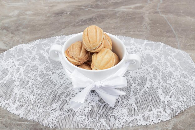 Biscuits en forme de noix dans un bol blanc.