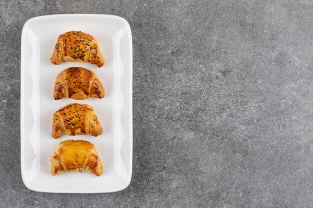 Biscuits frais faits maison d'affilée sur une plaque blanche